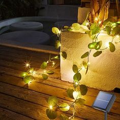 some lights that are on top of a wooden table in front of a planter