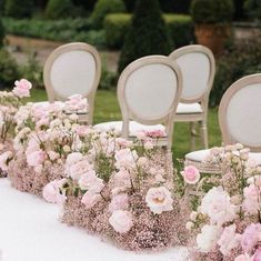 rows of chairs lined up with pink flowers on the table and white linens down the aisle