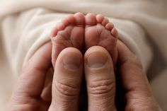 a baby's feet are being held in the air