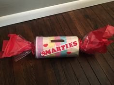 two wrapped candy bags sitting on top of a wooden floor next to each other with the words smarties printed on them