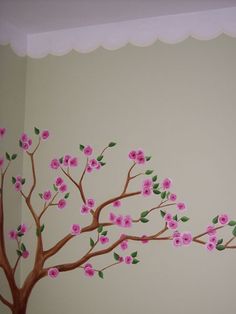 a tree painted on the wall with pink flowers