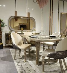 a dining room table with chairs and a mirror on the wall in front of it