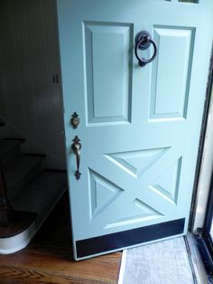 a blue door with an iron handle on the front and side panels that are painted white