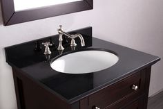 a bathroom sink sitting under a mirror next to a wooden counter top with two faucets