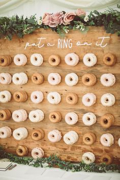 doughnuts are arranged on a wooden board that says put a ring on it