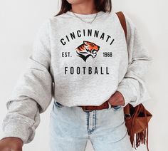 WELCOME TO MY STORE ♥️ This Cincinnati Bengal, Cincinnati Football Sweatshirt, Vintage Style Cincinnati Football Shirt, Cincinnati Shirt, Bengals Sweatshirt. Please check Color and Size Charts before placing the order. You can find them in the listing's photos (Depending on what device you are viewing this listing colors may vary slightly). *Please check Color and Size Charts before placing the order. You can find them in the listing's photos (Depending on what device you are viewing this listin Fall Season Team Name T-shirt With Crew Neck, Bengals Sweatshirt, Bengals Football, Football Sweatshirt, Football T Shirt, Sweatshirt Vintage, Football Shirt, Size Charts, Football Shirts