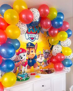 a birthday party with balloons and paw patrol theme on the wall, along with an assortment of treats