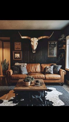 a living room filled with furniture and a cow skull on the wall