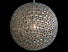 a round light fixture hanging from a black ceiling