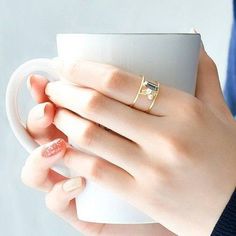 a woman holding a coffee mug with her hands