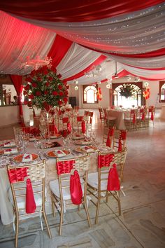 the tables are set with red and white linens for an elegant wedding reception or party