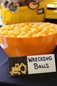 a bowl filled with corn balls sitting on top of a table next to a sign that says wrecking balls