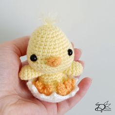 a small crocheted yellow bird sitting in an egg shell