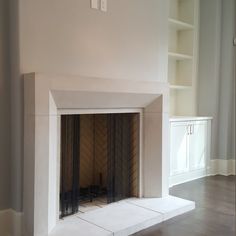 an empty room with a fireplace and shelves