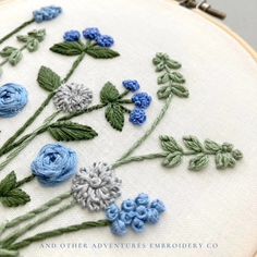 blue and white flowers are on the embroidery