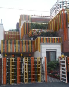 an orange and yellow fence is in front of a building with many balconies