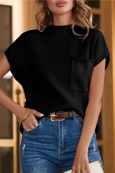 a woman in jeans and a black top is posing for the camera with her hand on her hip