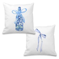 two pillows with blue and white designs on them, one has a bottle in the shape of a bow