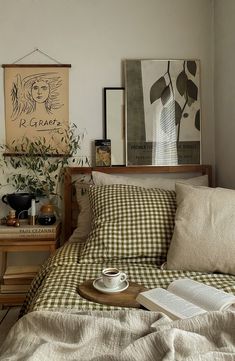 a bed sitting in a bedroom next to a window with lots of pillows on top of it