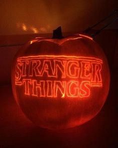 a pumpkin with the words strange things carved into it