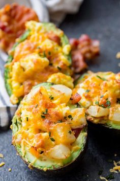 an avocado stuffed with eggs and other toppings sitting on a counter top