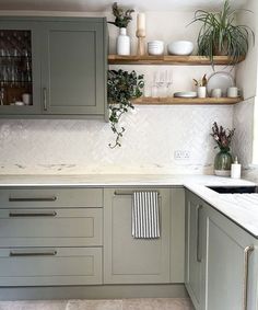 a kitchen with gray cabinets and white counter tops