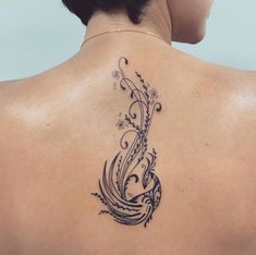 the back of a woman's neck with an intricate tattoo design on her left shoulder