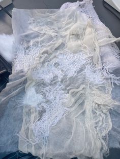 white lace is laying on top of an old piece of cloth