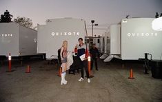 two people are standing in front of some white trailer trailers that say quixote