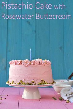 a pink cake sitting on top of a wooden table