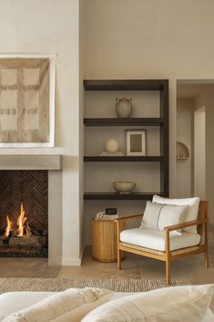 a living room filled with furniture and a fire place in front of a wall mounted fireplace