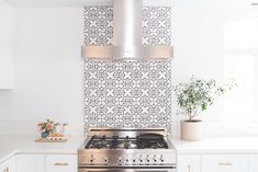 a stove top oven sitting inside of a kitchen next to white cabinets and counter tops