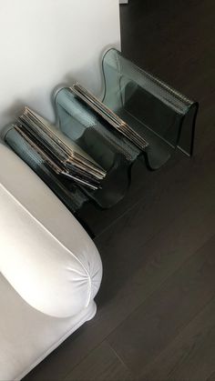 a white couch sitting on top of a hard wood floor next to a glass shelf