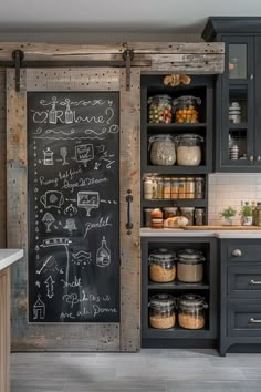 a chalkboard in the middle of a kitchen with lots of cupboards and drawers