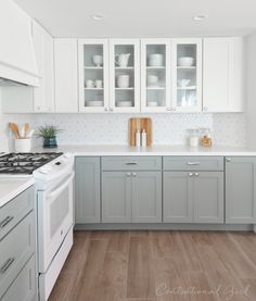 a kitchen with gray cabinets and white appliances