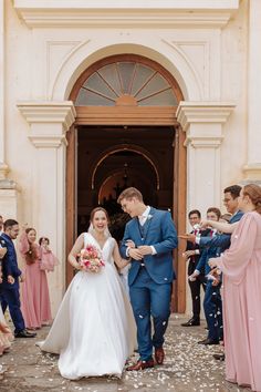 a bride and groom are leaving the church after their wedding ceremony with confetti thrown all around them