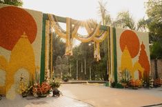 an outdoor ceremony with flowers and decorations on the wall, in front of a building