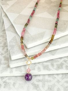 This delicate watermelon tourmaline & amethyst charm necklace is stunning! Beautiful watermelon tourmaline rondelle beads are separated by gold micro charlotte cut seed beads.  The necklace is anchored by a delicate 14k gold filled spring ring that opens and closes allowing you to change out your charms.  This necklace comes with a 8mm round amethyst charm wrapped in 14k gold filled wire. Add to, or swap out any charms you like!  A simple 14k gold filled clasp allows this necklace to be easily p Adjustable Tourmaline Gemstone Beads Jewelry, Tourmaline Jewelry With Natural Stones For Jewelry Making, 14k Gold Filled Briolette Gemstone Jewelry, Tourmaline Briolette Jewelry With Natural Stones, Briolette Tourmaline Jewelry With Natural Stones, Spiritual Tourmaline Gemstone Beads Jewelry, Gemstone Round Beads Jewelry Gift For Her, Handmade Tourmaline Dangle Jewelry, Tourmaline Jewelry With Round Beads As Gift