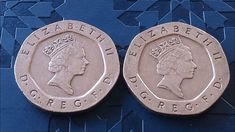 two british pound coins sitting side by side on a blue tablecloth with geometric designs