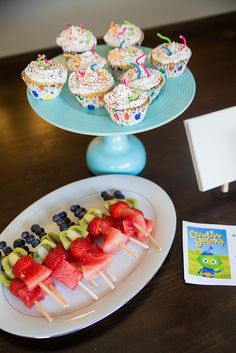 there are cupcakes and fruit on the plate with strawberries, watermelon