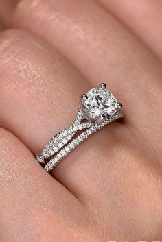 a woman's hand with a diamond engagement ring on her left and a wedding band on the right