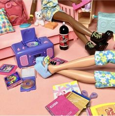 there is a doll laying on the floor with her feet up and toys all around