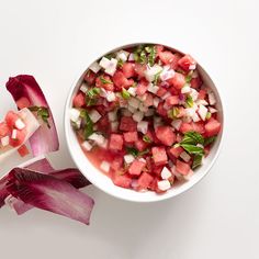 a white bowl filled with watermelon and radishes on top of a table