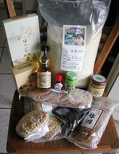 an assortment of food sitting on top of a wooden chair next to a bag of rice