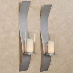 two wall sconces with candle holders on each side and one light in the middle