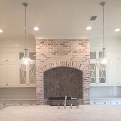 an image of a kitchen with a fireplace in the center and white cabinets around it