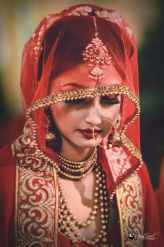 a woman wearing a red veil and jewelry