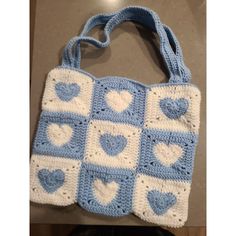 a blue and white crocheted bag with hearts on it