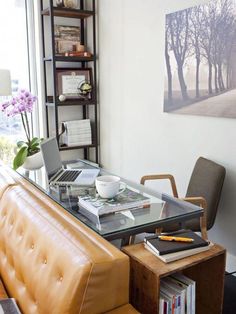 a living room with a couch, coffee table and bookshelf on the wall