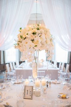 a centerpiece with flowers and candles on a table